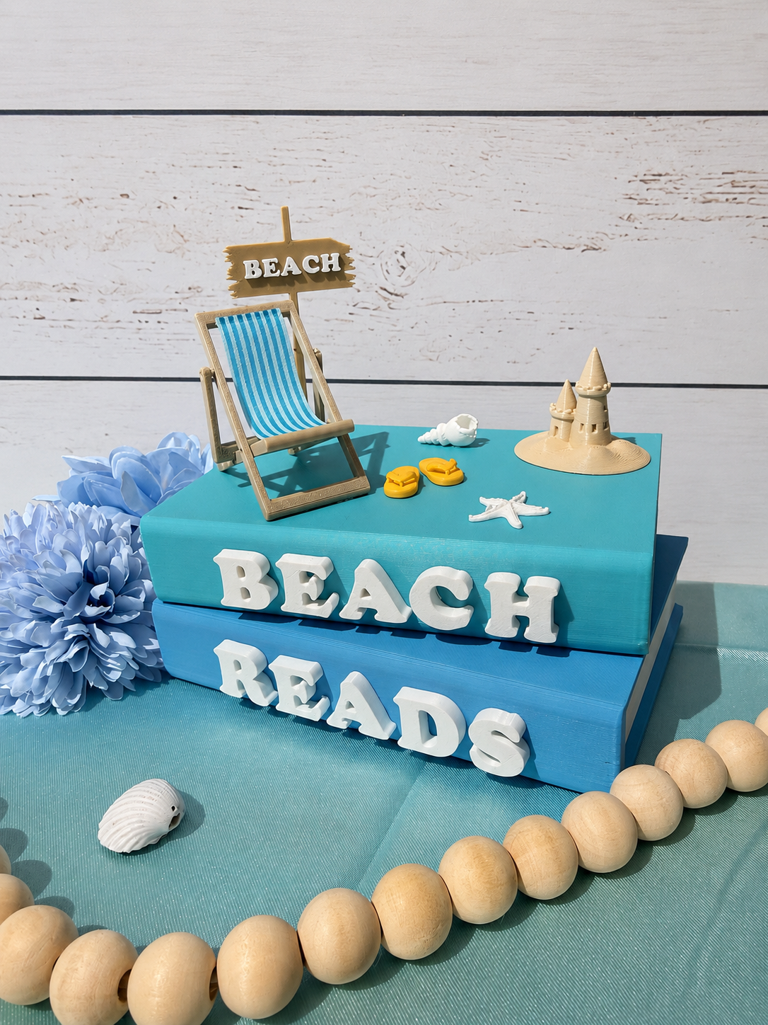 Beach Reads book stack with deckchair, sand castle and seaside accessories topper