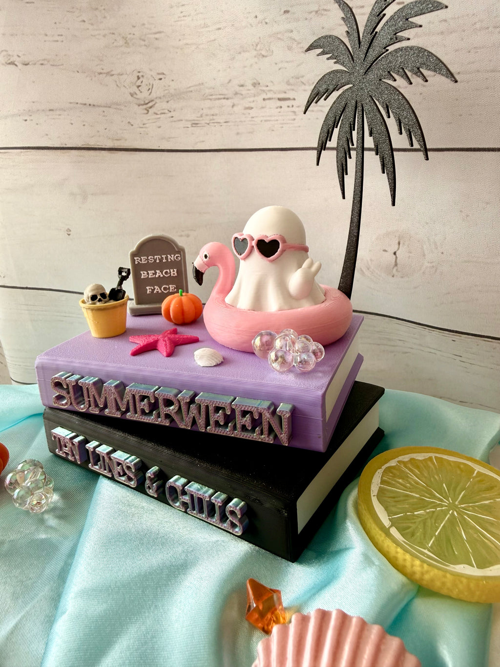 Summerween book stack with ghost in flamingo ring float and palm tree topper
